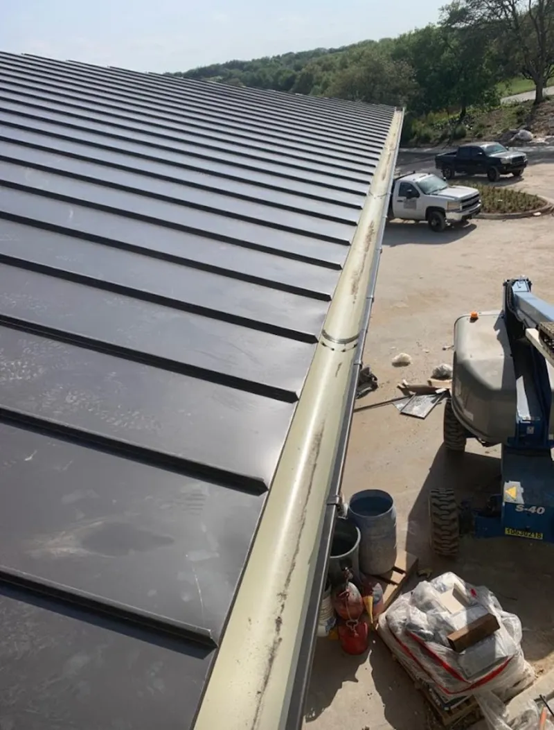 Standing seam panel and gutter detail on a metal roofing jobsite in Eden